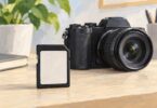 Generic illustration of a full-size SD memory card beside a mirrorless camera.