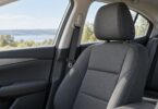 Empty adult car seat with its factory-style head restraint and seat belt.