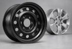 Generic unbranded black steel wheel beside a silver alloy wheel.
