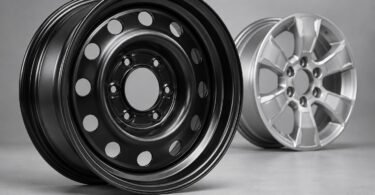 Generic unbranded black steel wheel beside a silver alloy wheel.