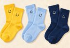 Illustration of yellow, pale blue, and navy socks with smiling-face motifs.