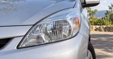 Generic clear front headlamp on an unbranded silver compact car.