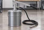 A generic unbranded manual grease bucket pump with a lever and coiled delivery hose.