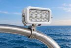 Generic unbranded deck floodlight attached to a curved metal boat-tower tube.