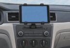 Illustration of a generic tablet held horizontally by a clamp mount at a car audio console.