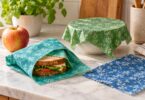 Generic colorful reusable waxed fabric food wraps around a sandwich and covering a bowl.