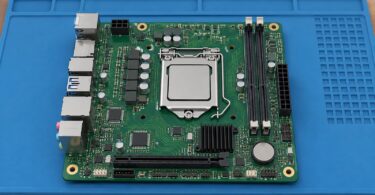Generic unbranded compact motherboard on a work mat.