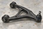 Illustration of an unbranded automotive suspension control arm with two pivot bushings and a ball-joint end.