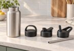 Unbranded reusable water bottle beside three separate generic lid styles and a reusable straw.