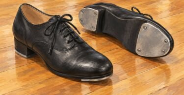 Illustration of black lace-up tap shoes showing metal toe and heel taps.