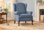 Illustration of a blue wingback chair with curved legs beside a measuring tape.