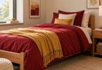 Editorial illustration of a dorm bed with garnet, gold and cream bedding.