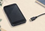 Generic older smartphone beside an unconnected Micro-USB cable.