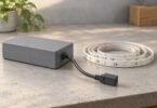 Generic closed power-supply housing beside an unlit disconnected coil of LED strip.