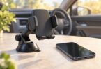 Generic adjustable car phone cradle and suction mount beside a phone with a blank screen.