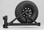 Generic spare wheel attached to a black triangular swing-away tire-carrier frame, shown without a vehicle.