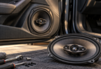 AI-generated illustration of a round speaker in a car door and an oval car speaker on a workshop mat.