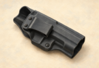 Illustration of a plain empty rigid holster on a neutral surface.