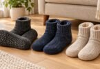 Charcoal, navy and oatmeal slipper socks, with grip dots visible on one sole, on a wooden floor.
