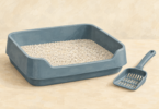 Illustration of a clean litter tray with granules and a separate litter scoop.