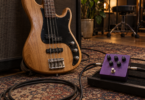 A four-string bass guitar beside an unbranded purple effects pedal in a rehearsal space.