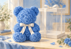 Illustration of a blue rose-shaped bear with a white bow beside an empty clear gift box.