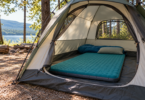 Thick teal sleeping mat with a pillow and sleeping bag inside an open tent