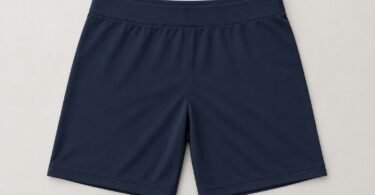 Illustration of empty, plain navy fitted athletic shorts laid flat on a light surface