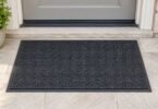 Illustration of a plain charcoal entry mat lying flat on a dry stone doorstep.