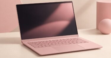 Illustration of an unbranded pink laptop with a blank screen on a pale desk
