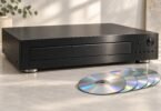 Illustration of an unbranded home stereo CD player beside a group of compact discs.