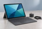 Illustration of unbranded detachable tablet with a keyboard, USB-C cable and power adapter on a desk