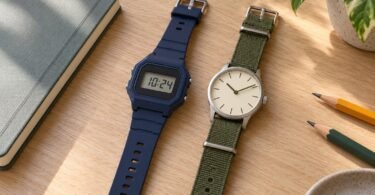 Illustration of a navy digital watch and an olive-strap analog watch beside a notebook and pencils on a wooden desk