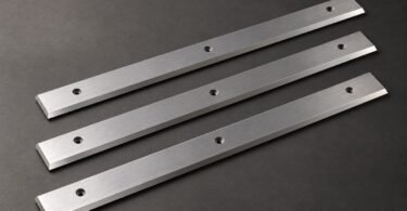 Illustration of three generic straight planer knives on a gray surface.