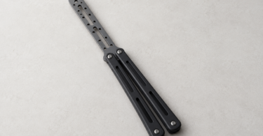 Illustration of a generic blunt butterfly practice trainer with a rounded perforated insert on a pale tabletop