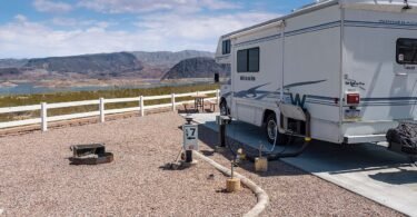 Motorhome parked on a campsite pad overlooking Lake Mead and desert mountains