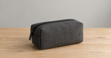 Illustrative image of a closed, unbranded gray storage pouch on a wooden table.
