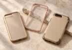 Three generic gold and rose-gold smartphone cases arranged on pale stone