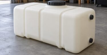An unbranded rectangular plastic storage tank with capped fittings on a workshop floor