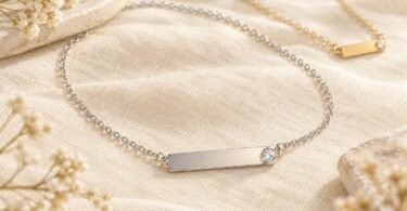 Illustration of blank silver-tone and gold-tone necklace pendants with clear crystal accents on ivory linen.