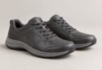 A pair of unbranded gray lace-up walking shoes on a neutral background