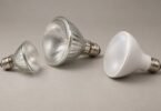 Three unbranded reflector light bulbs with screw bases on a neutral surface