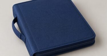Illustration of a plain navy zippered binder with a carry handle on a light surface
