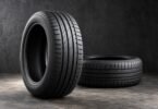 Two unbranded low-profile tires without wheels, one upright and one lying flat