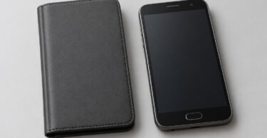 Closed unbranded charcoal folio cover beside a generic older smartphone with a blank screen and physical home button