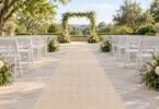 Illustration of empty outdoor wedding aisle with a cream runner on a level stone patio between white chairs