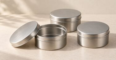 Illustration of three plain silver metal tins, including one open tin with its lid beside it.