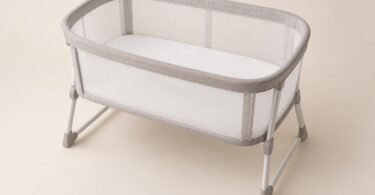 Illustration of an empty mesh-sided bassinet with a flat white sleep pad on a level floor