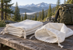 Empty woven drawstring bags on a camp table beside a backpack, with mountains in the background.