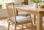 Blue-and-cream striped seat cushions tied to wooden chairs beside a kitchen table